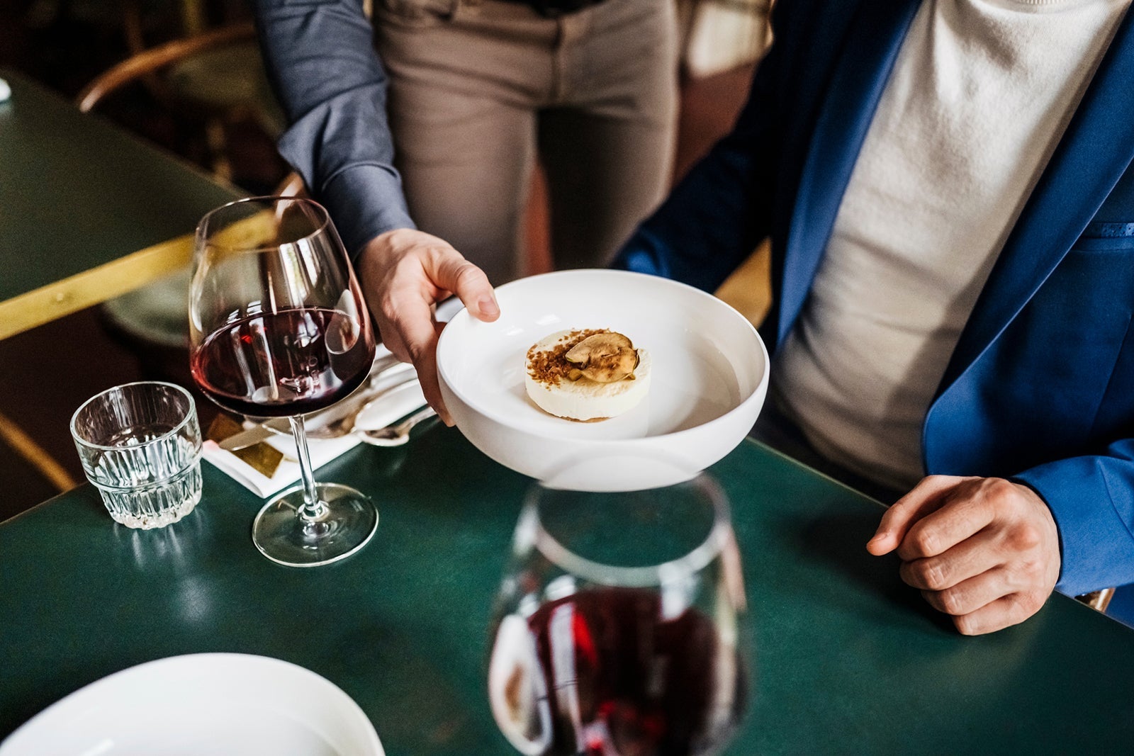 Waiter Serving Customer Starter Dish In Restaurant