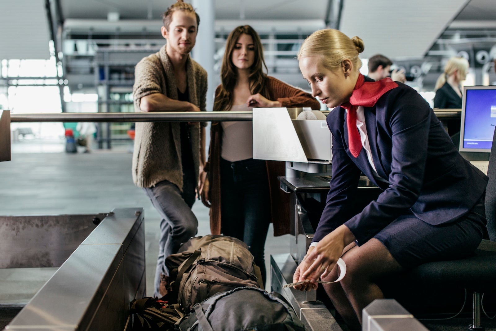 Young Couple At Airport Baggage Drop Off