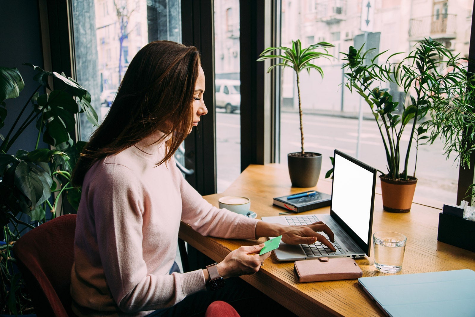 Young woman holding credit card and using laptop
