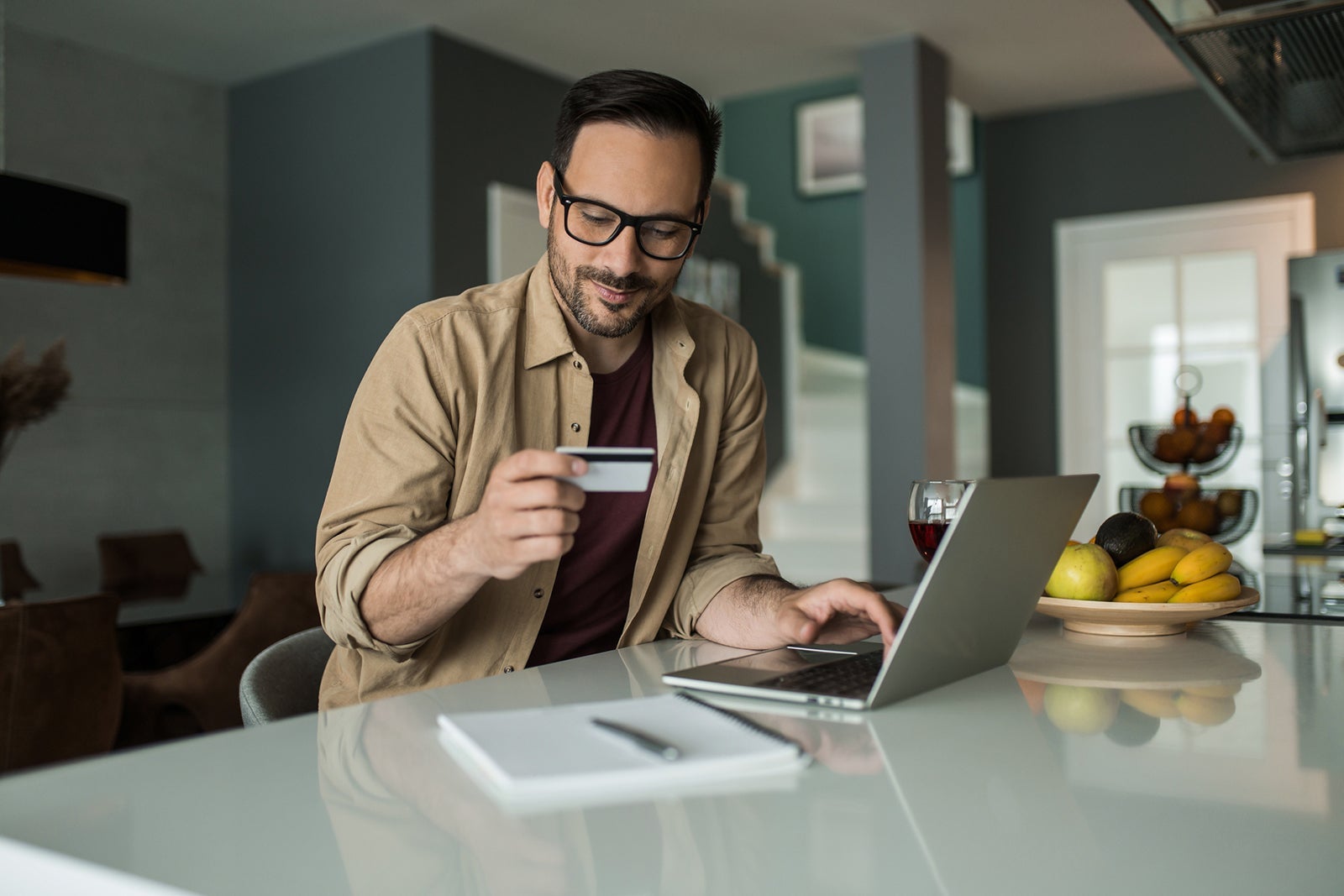 Young man investing his digital money online using credit card at home.