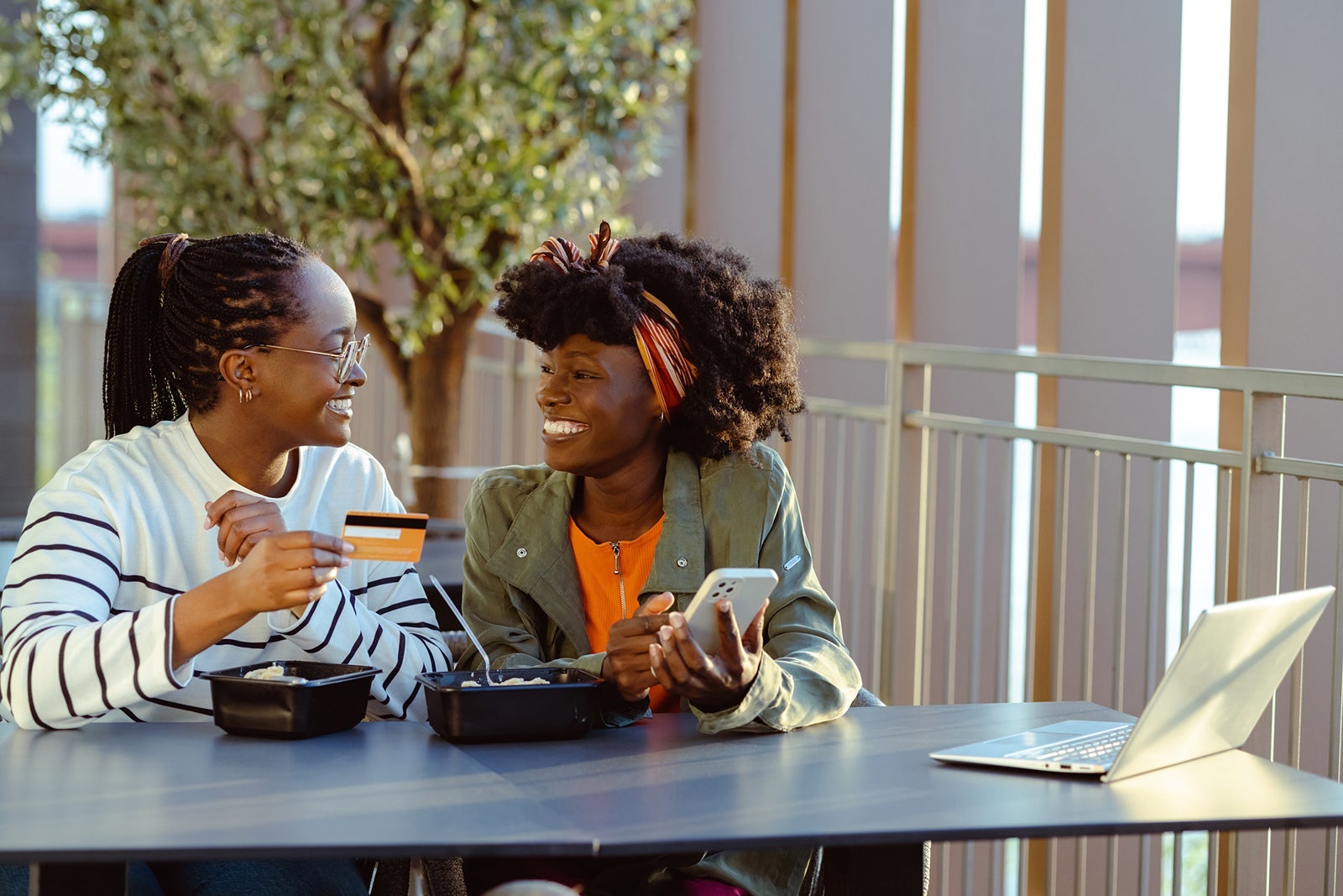Friends eating fast food and using credit card for online payment