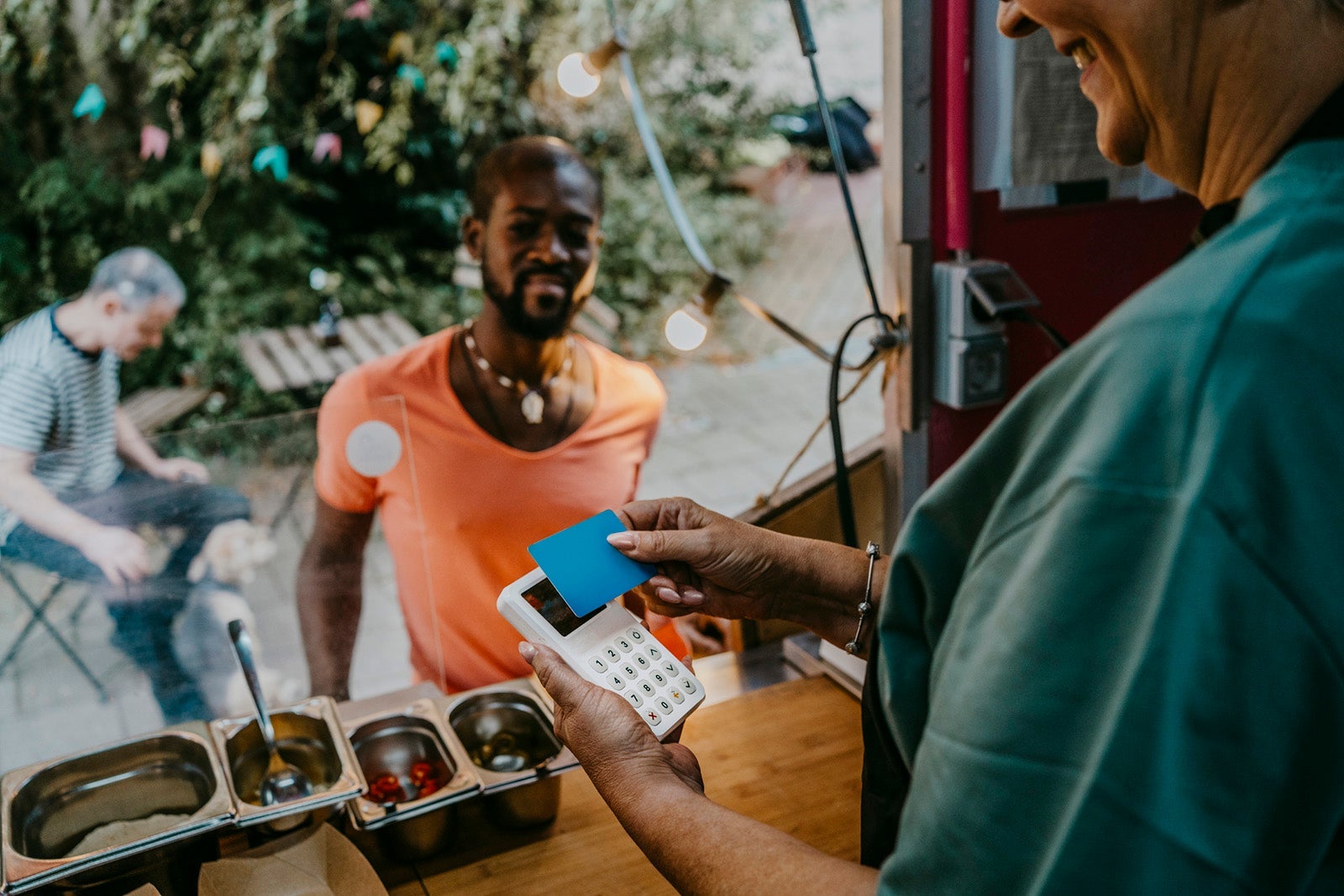 Senior woman using credit card reader in concession stand