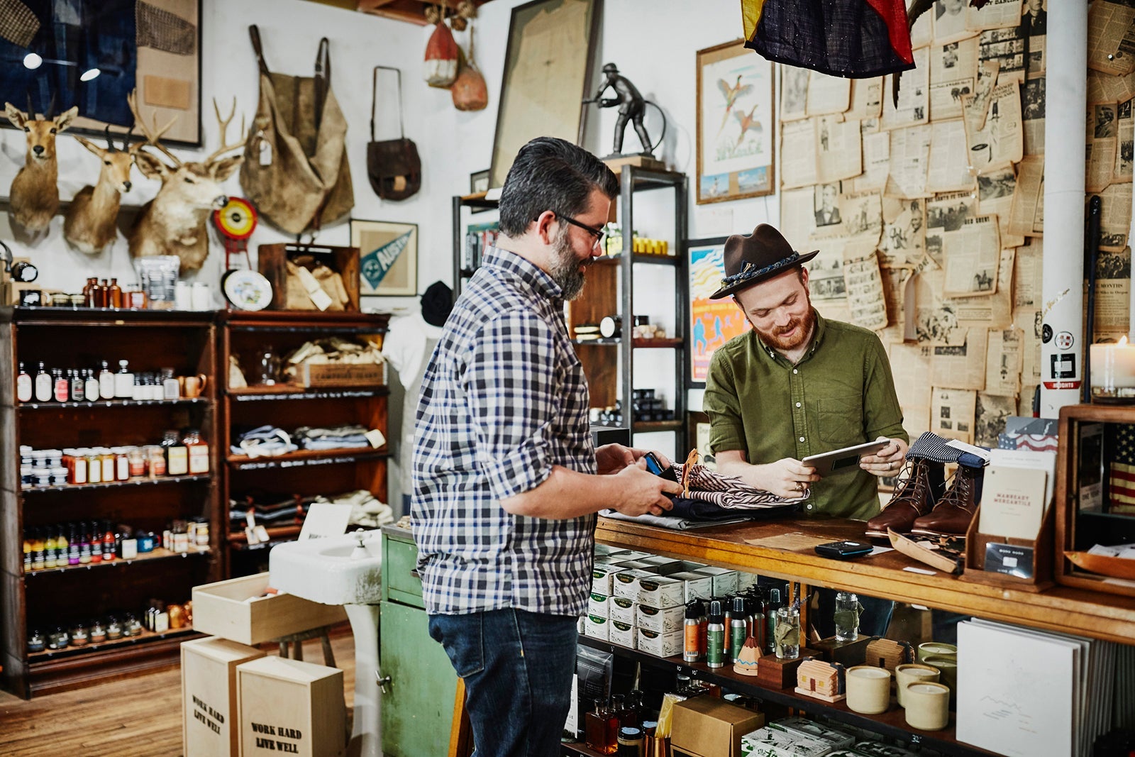 Shop owner helping customer check out in mens boutique