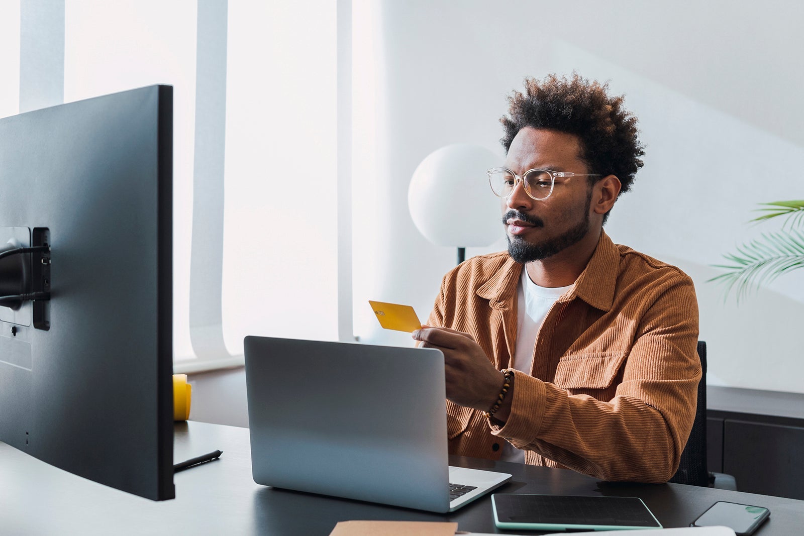 Businessman with credit card sitting at office