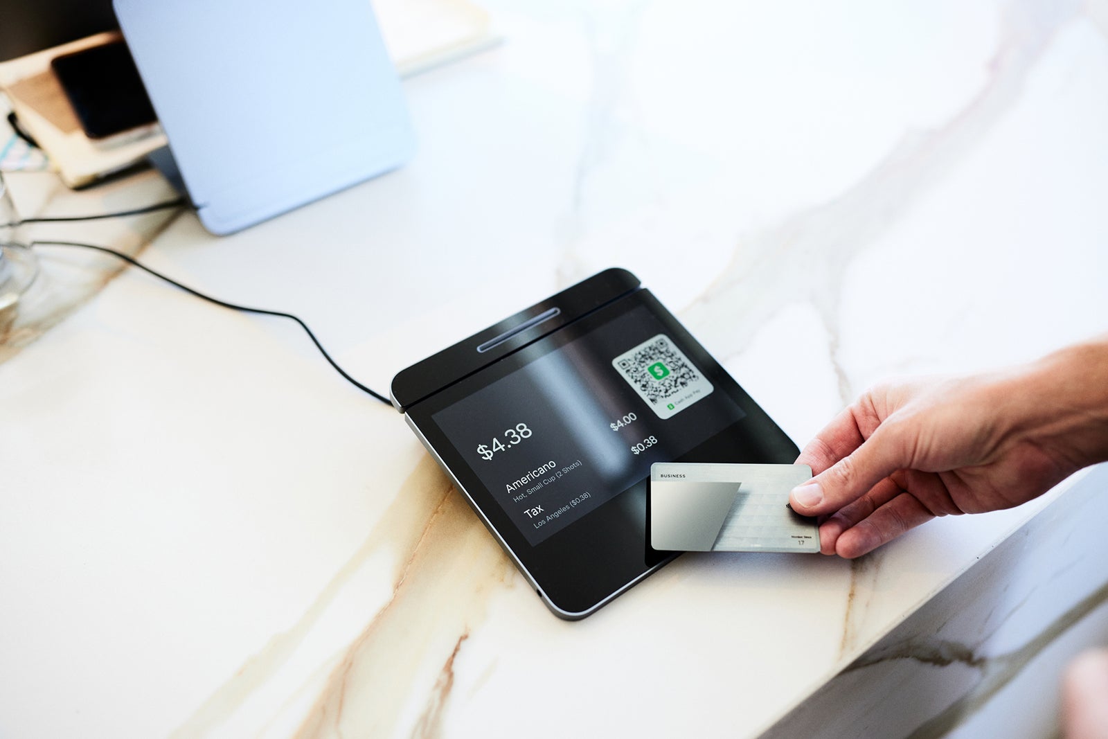 Hand of male customer paying with credit card on modern POS system