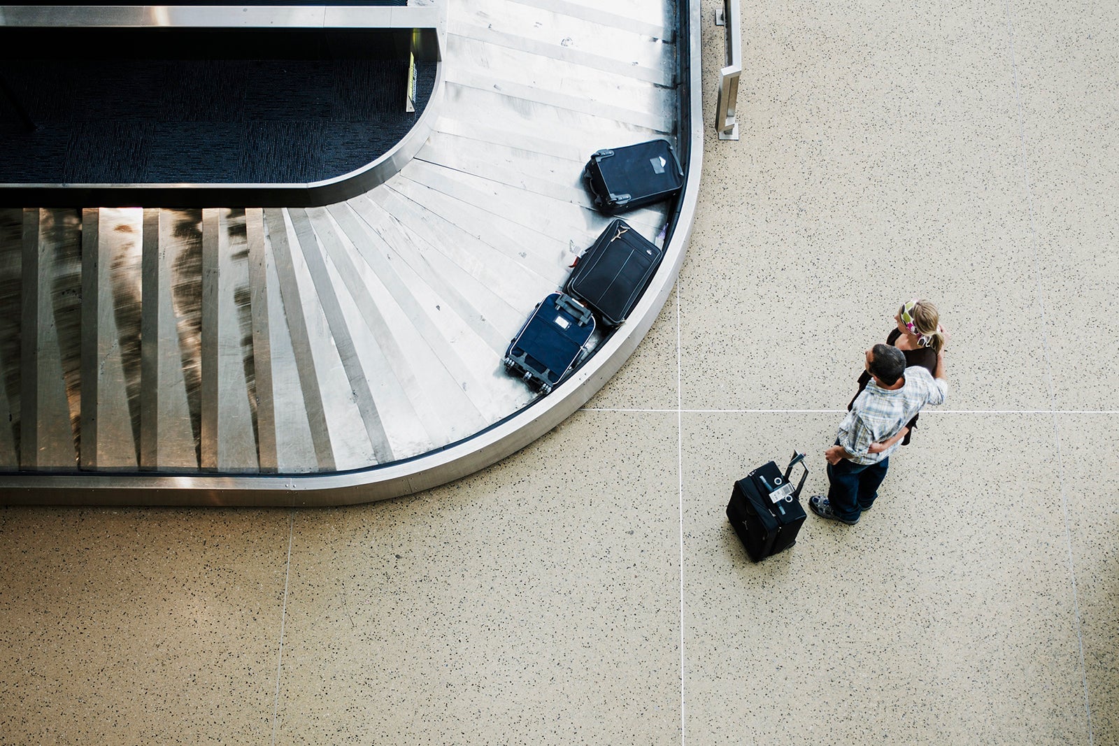 Couple waiting for luggage at baggage claim