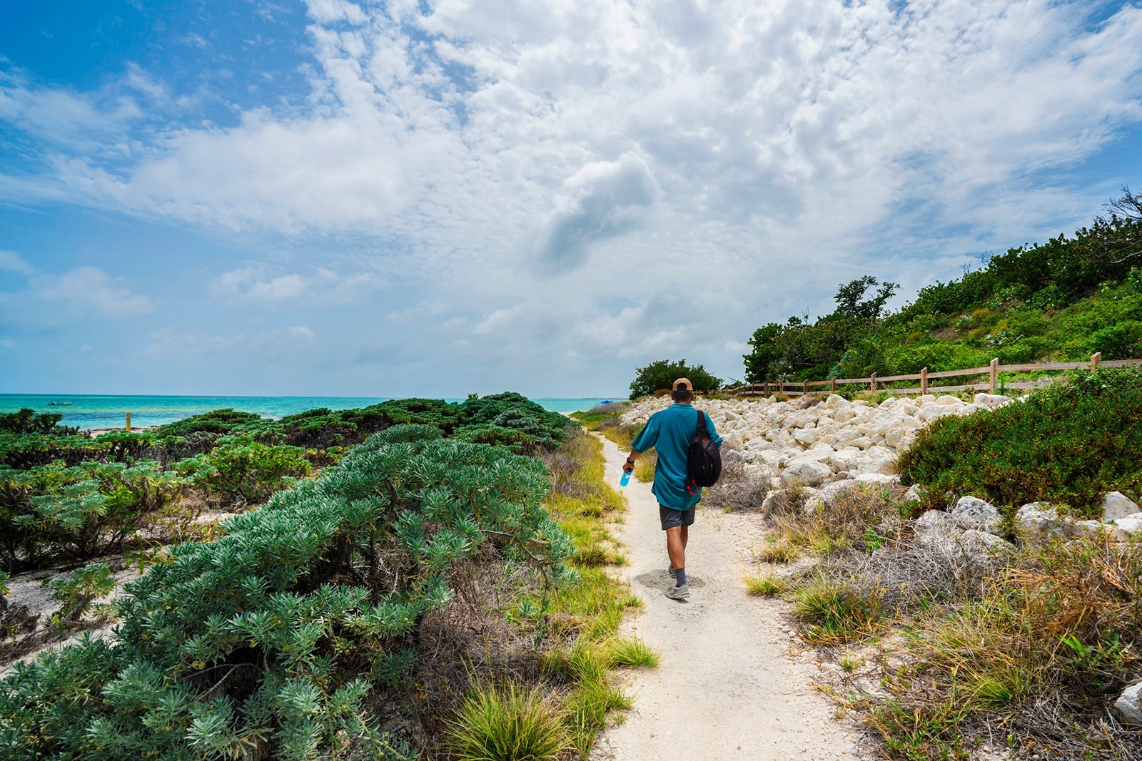 Man walking on the footpath to the ocean.