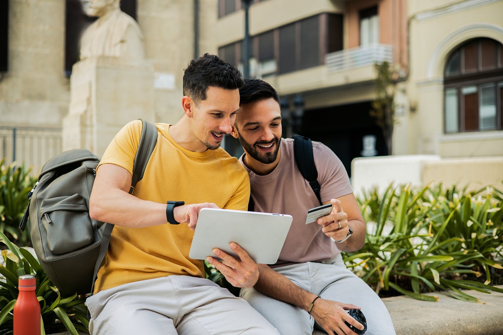 Two men on vacation shopping online on the street