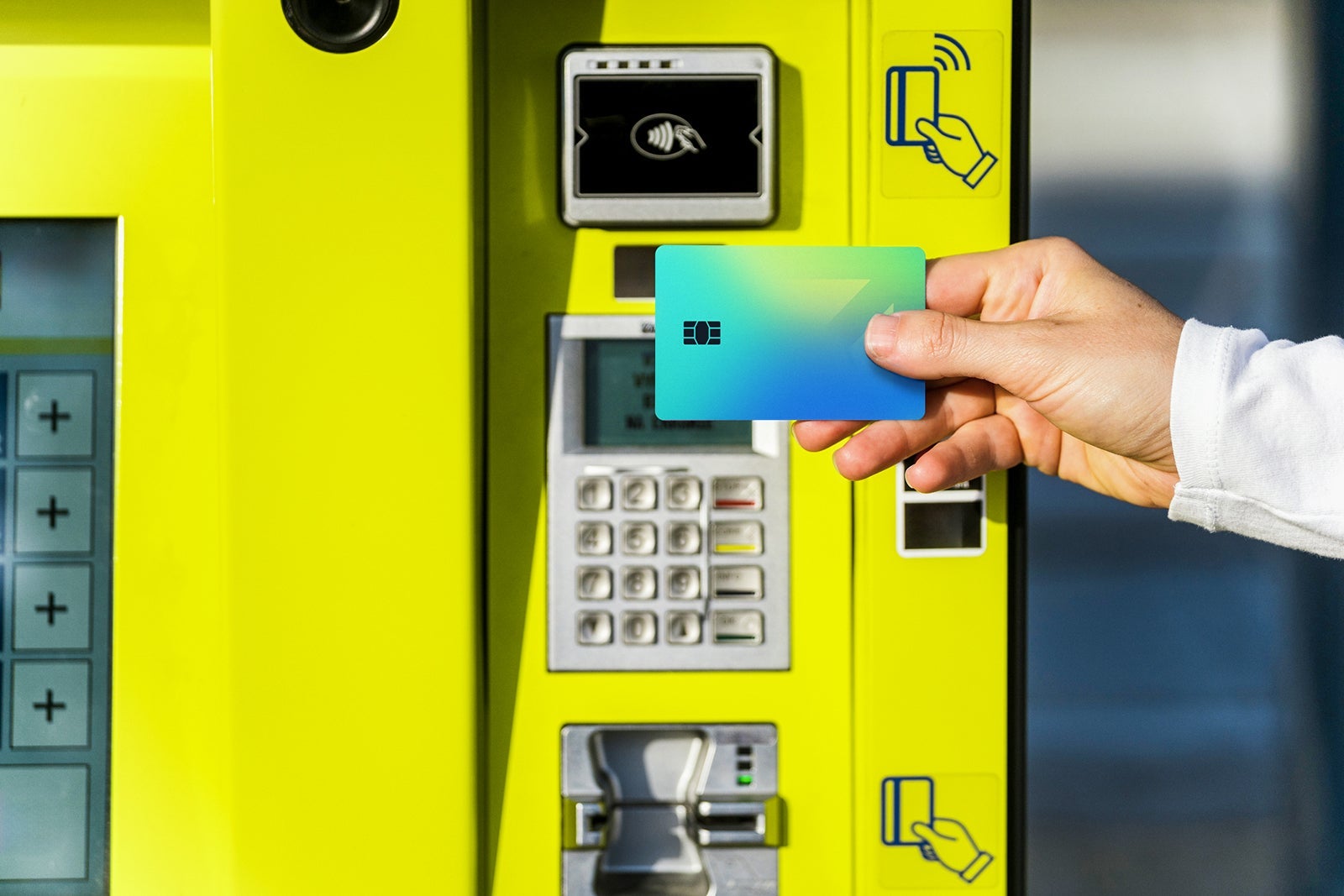 Selective focus on female hand holding travel pass for public transport against atm