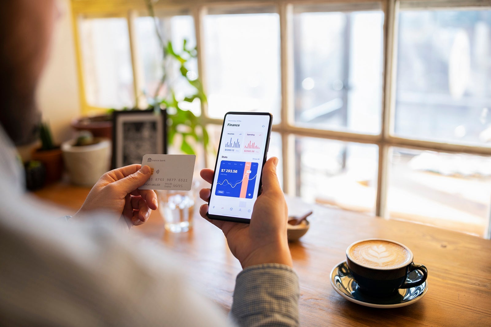 Man making online payment through credit card at home while drinking coffee.