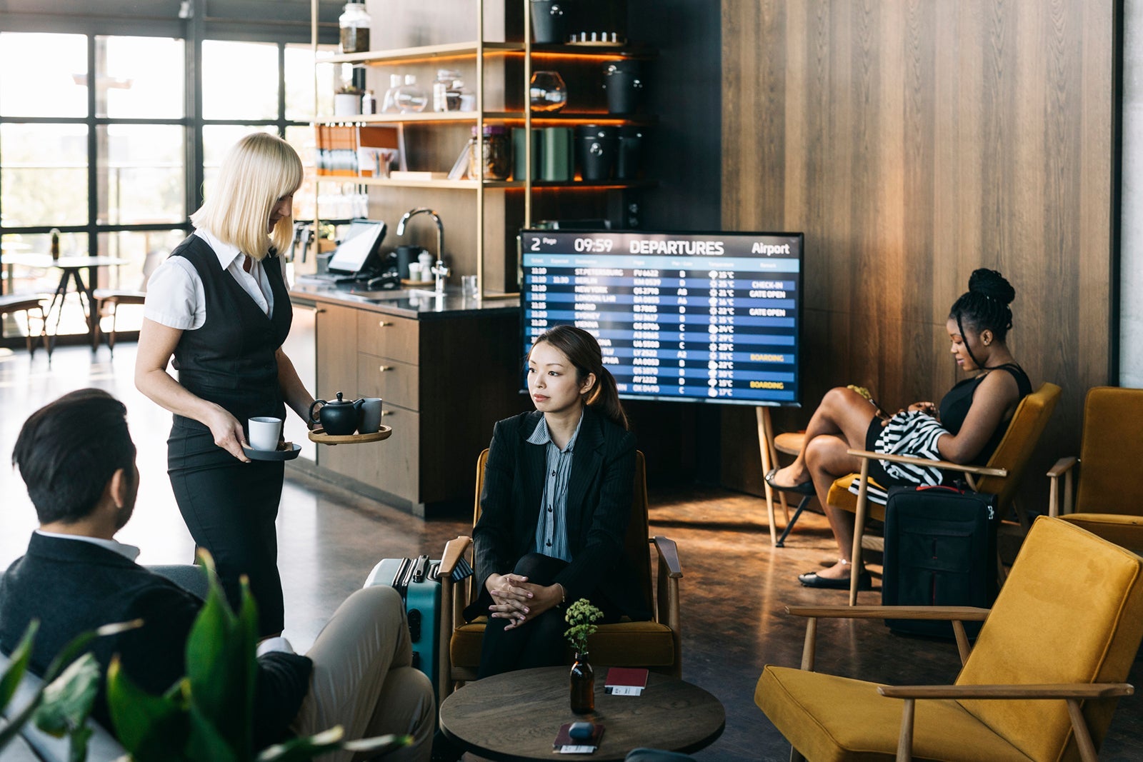 Frequent flyers enjoying the benefits and service of the first class lounge at the airport.