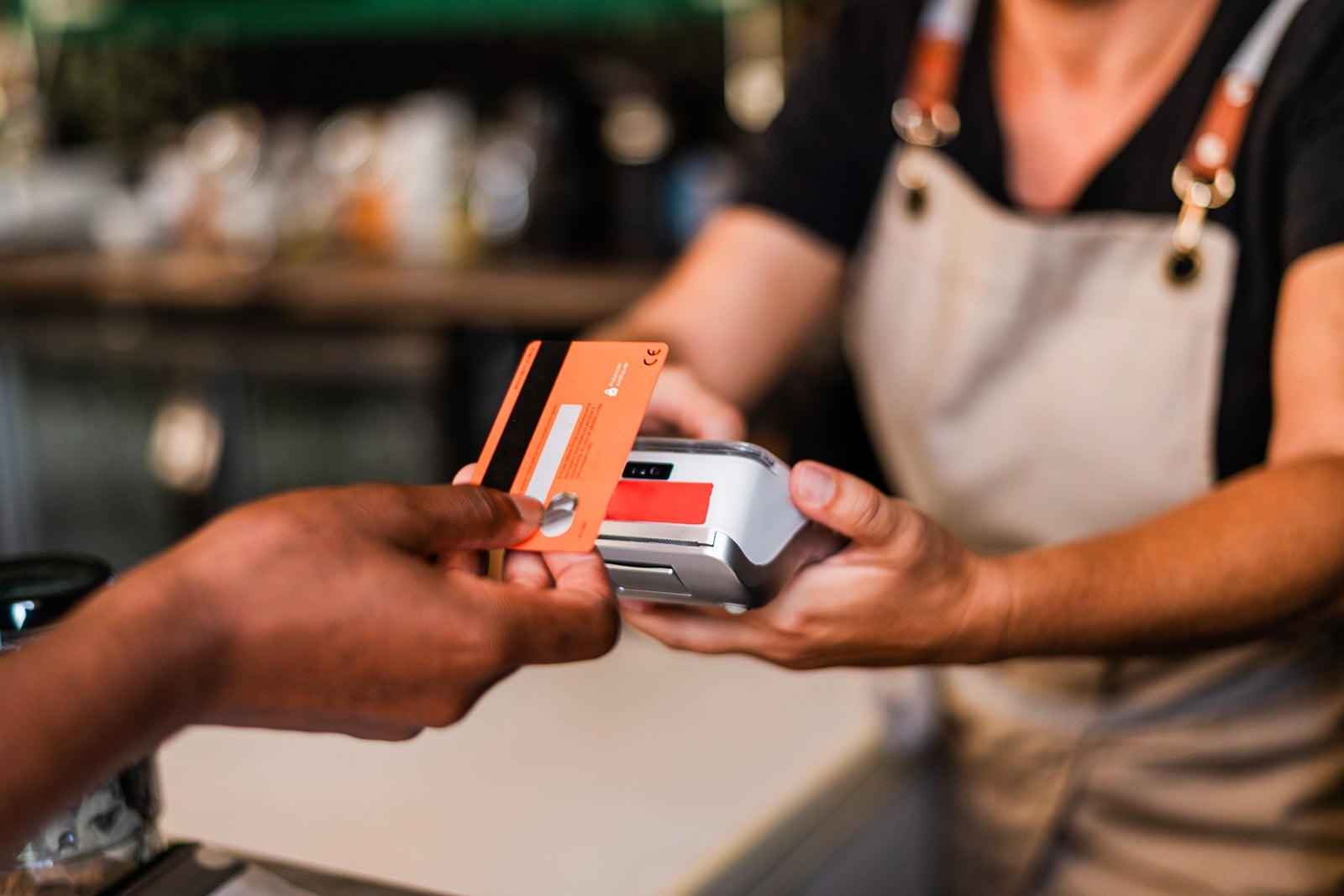 Woman using card to pay with contactless in a bar
