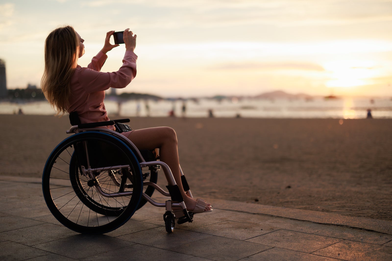 Accessible Beach Adventure: Disabled Woman in Wheelchair Enjoys Scenic Sightseeing and Photography at beachfront. Pattaya, Thailand