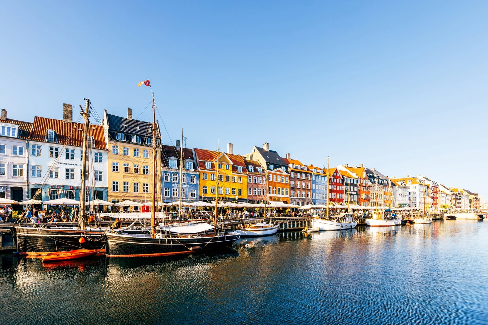 Multi-colored vibrant houses in Nyhavn harbour on a sunny summer day with clear blue sky, Copenhagen, Denmark