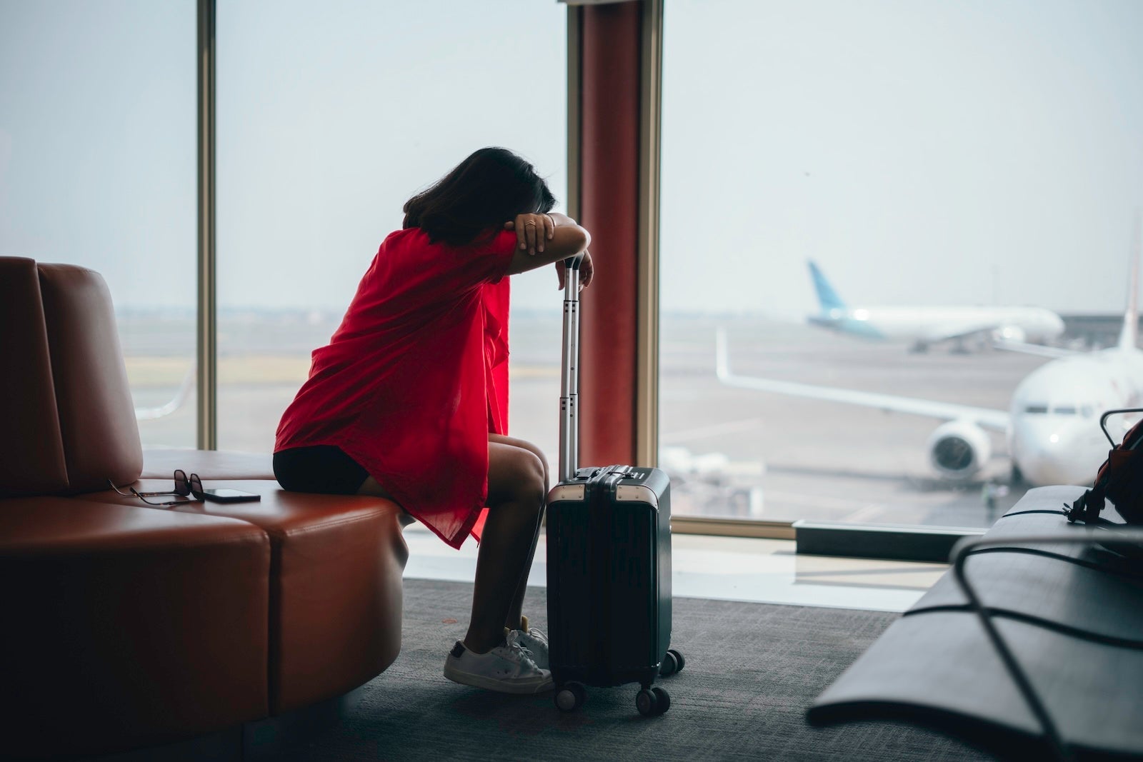 Frustrated young woman business traveler waiting in airport