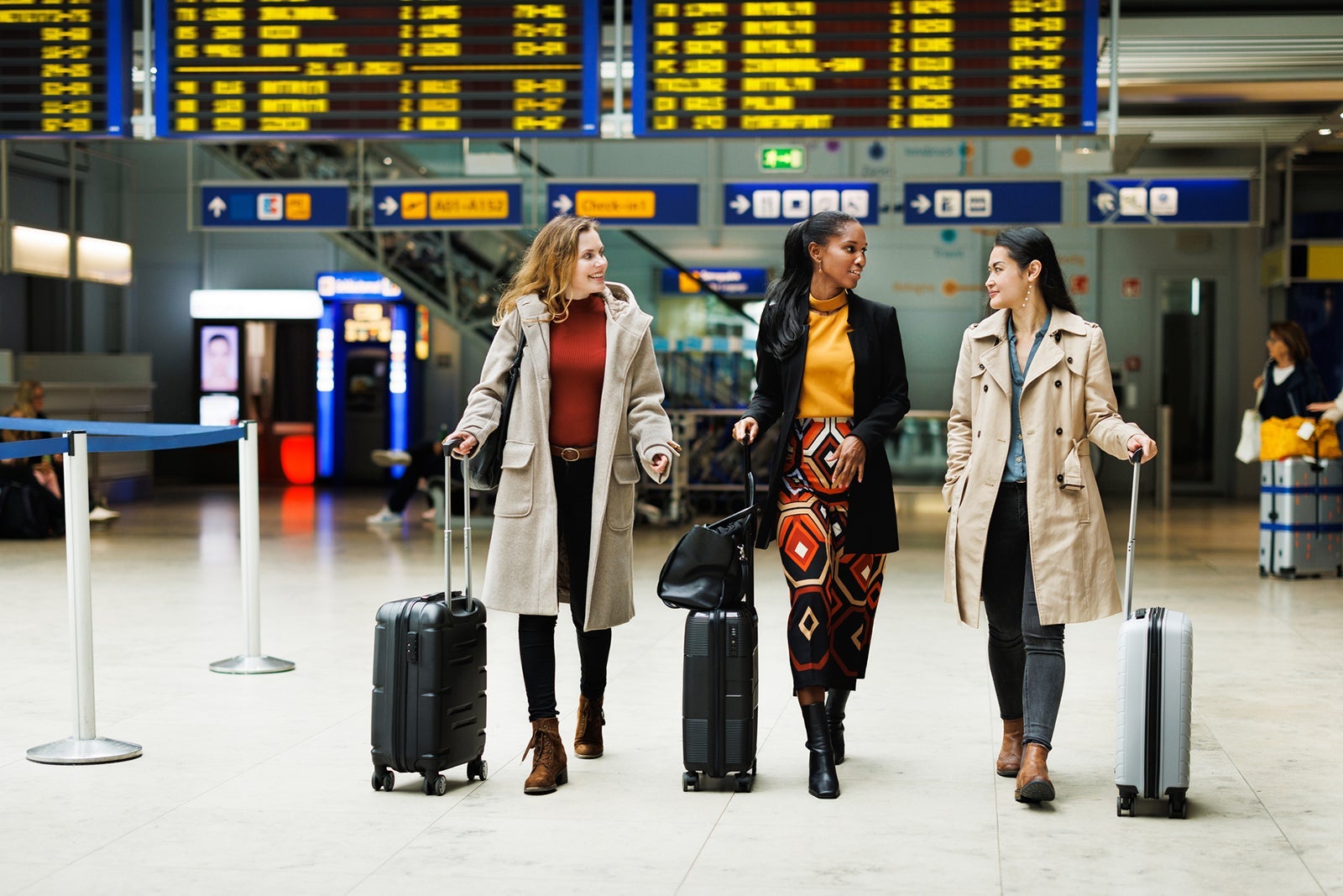 Three Businesswomen Walking Together To Catch A Flight