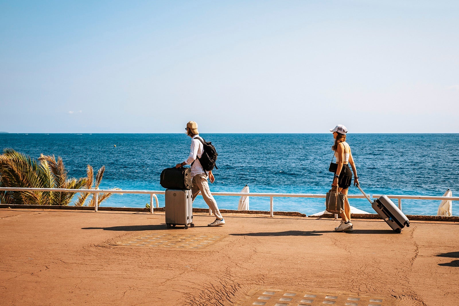 Young people with luggage at marina ready for sailing trip