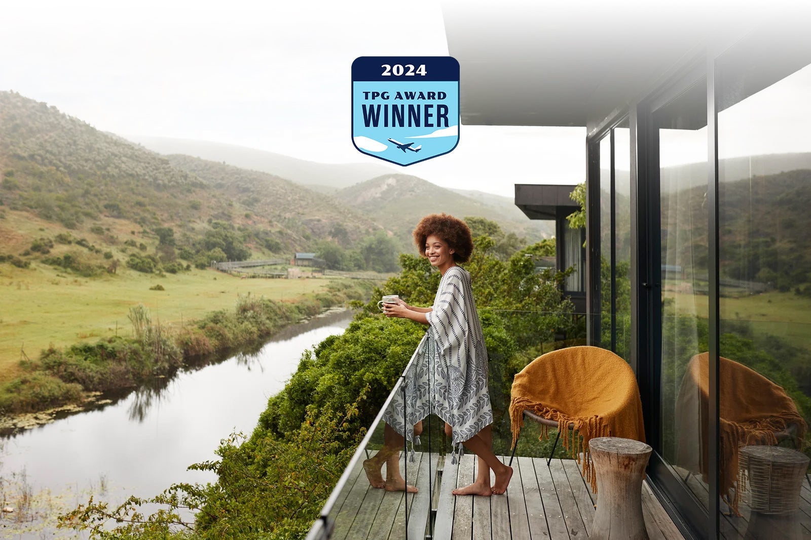 woman-with-coffee-cup-leaning-on-railing-in-safari-lodges-balcony_Klaus-Vedfelt