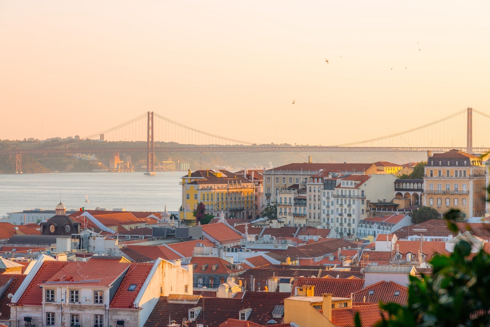 Lisbon, rooftops and bridge at sunset