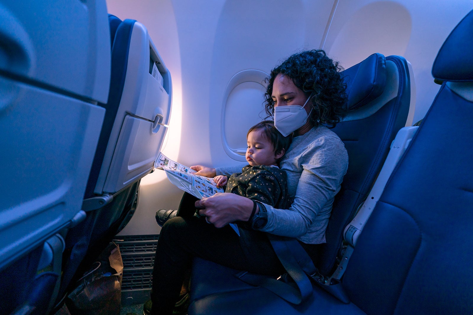 Mom reading to her toddler on airplane