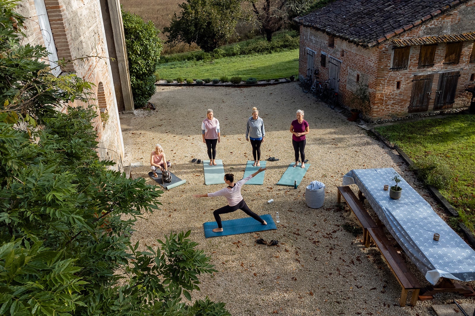 Yoga-instructer-teaching-yoga-class-outdoors-at-retreat-in-France_SolStock