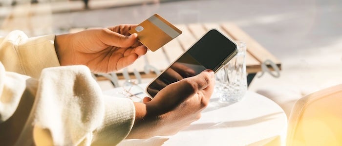 Woman using a credit card to pay online bills using mobile application