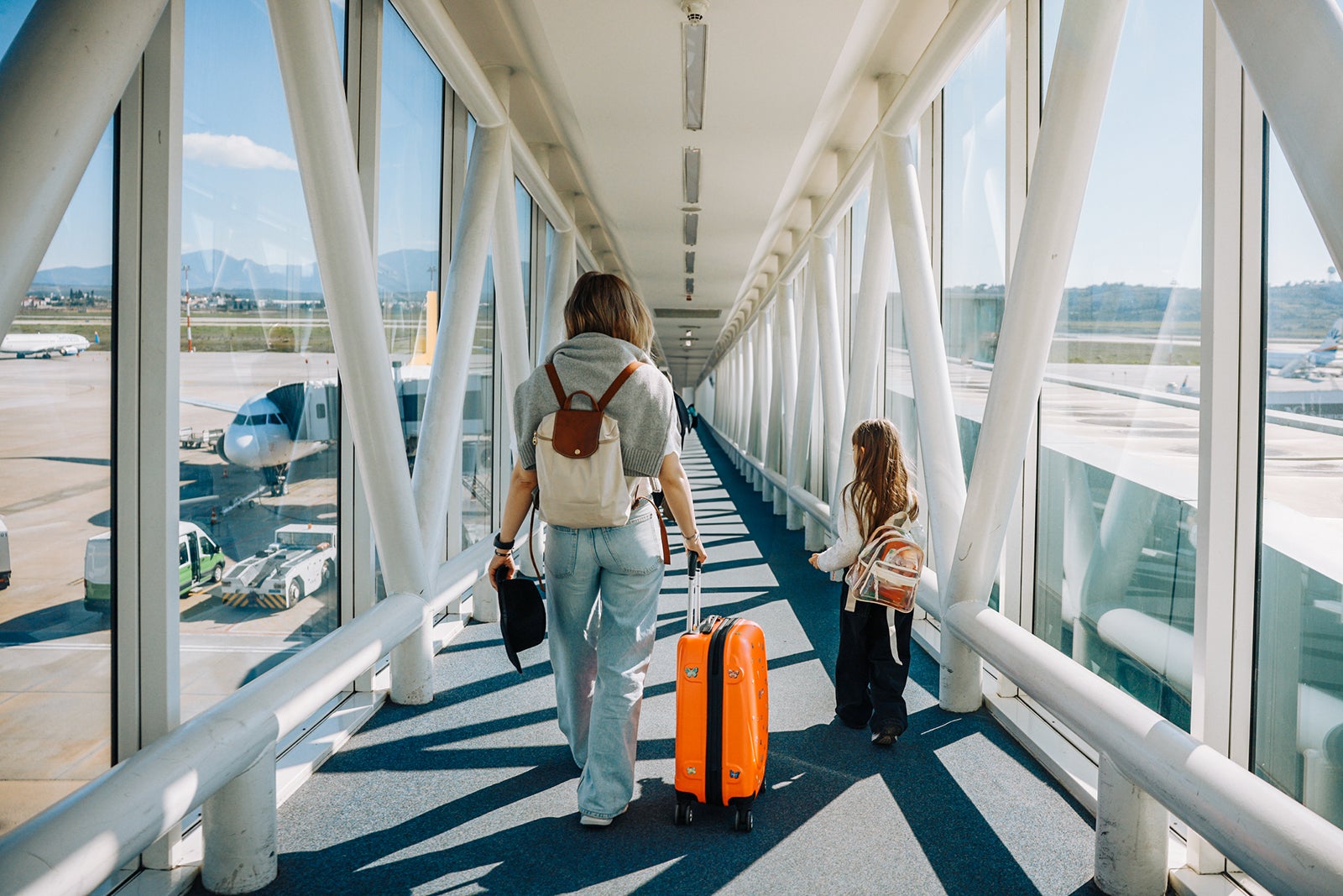 Woman with little girl and suitcases at the airport