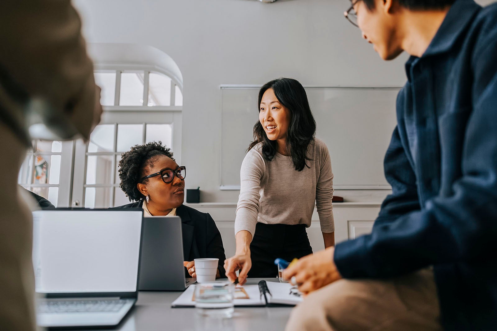 Female entrepreneur explaining business strategies to colleagues in meeting room at office