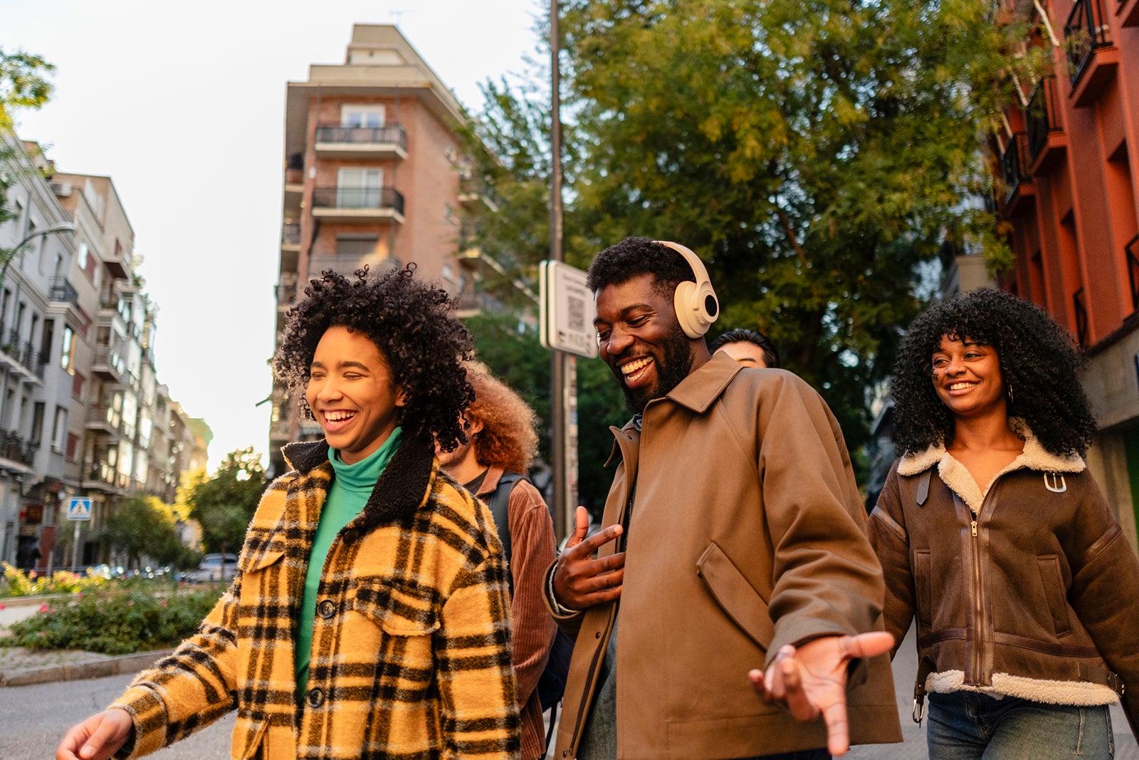 Happy multiethnic friends walking and talking together down the street