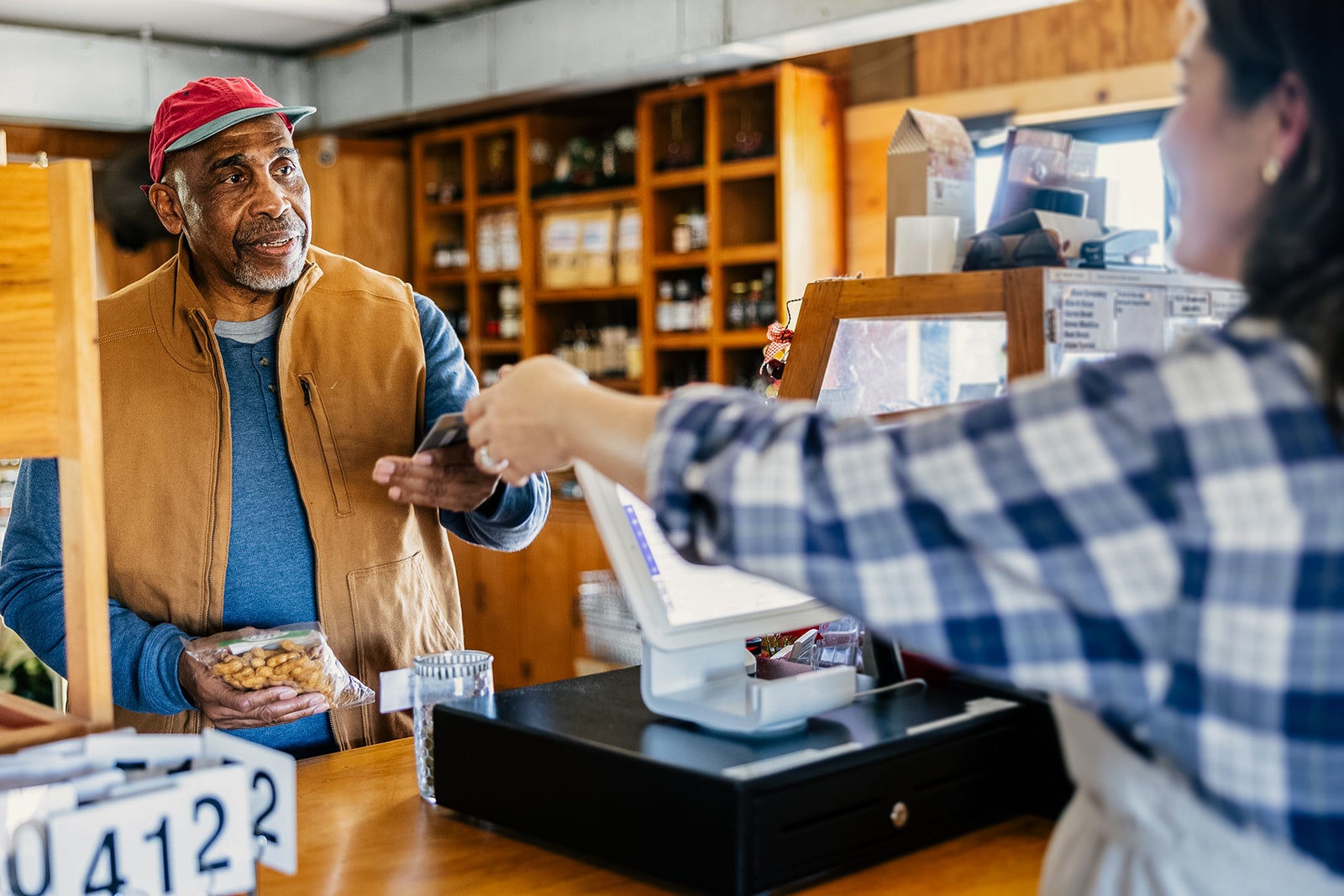 Senior man making purchase with credit card at cash register