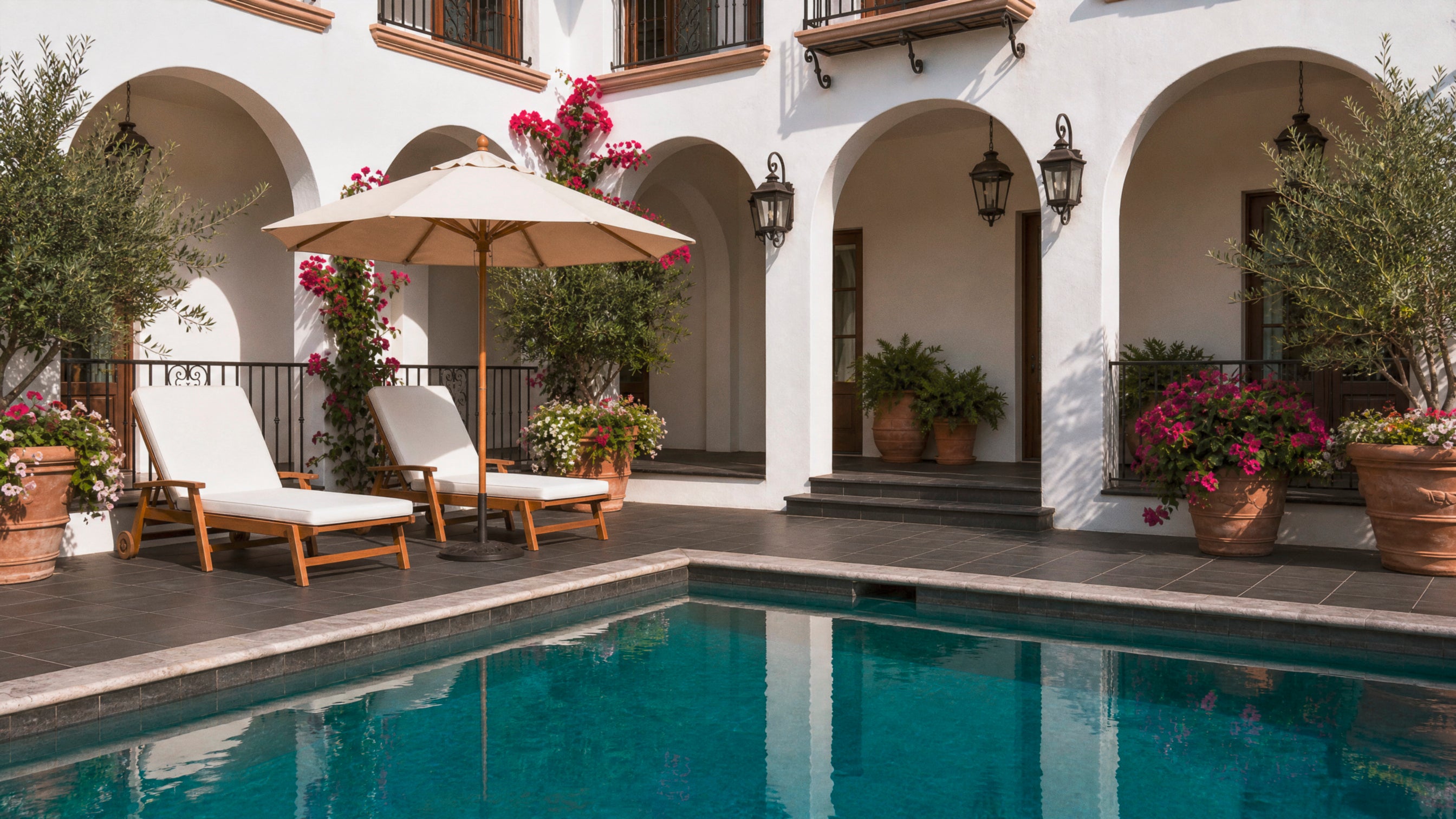 Poolside patio with lounge chairs and an umbrella
