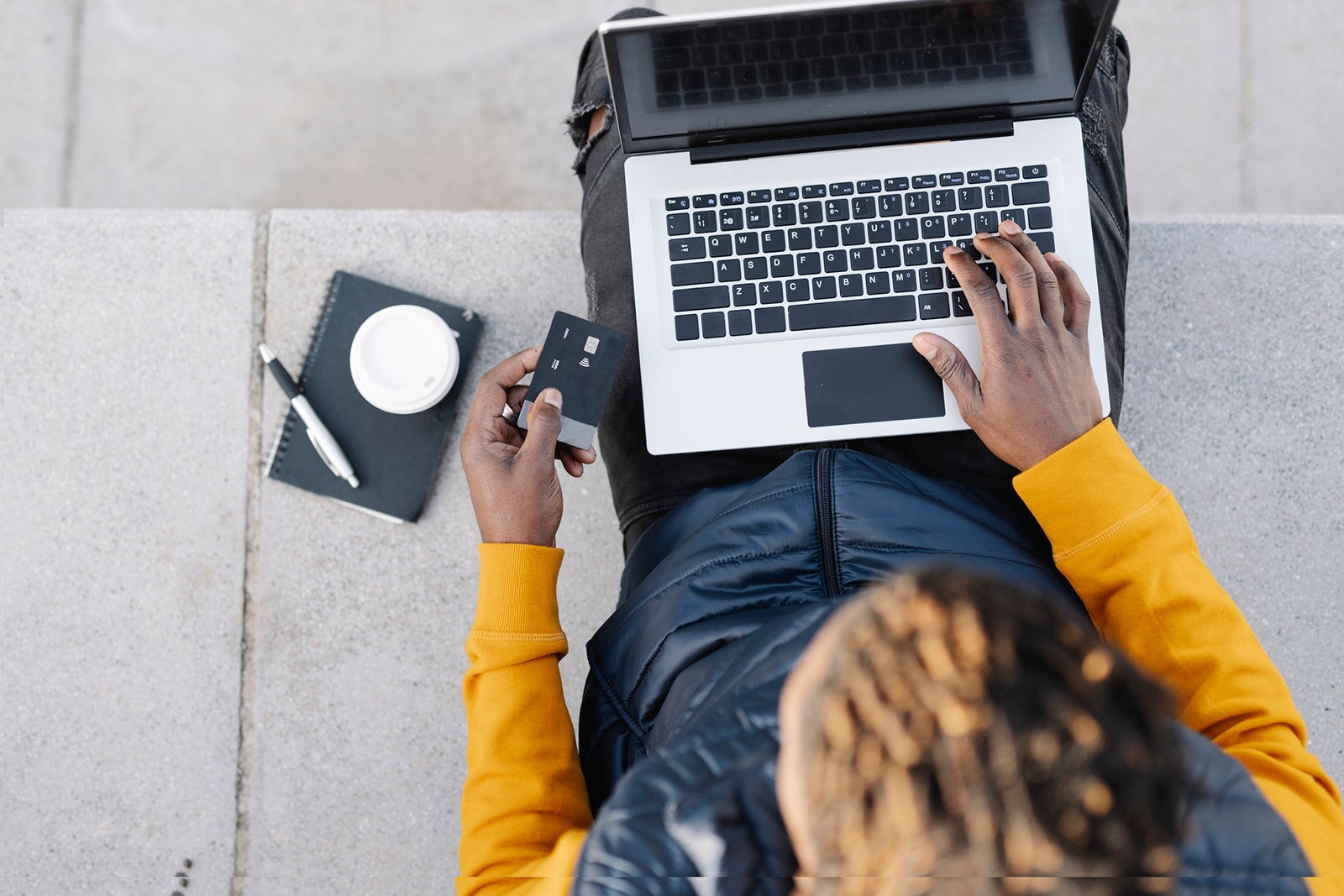 Man using laptop while holding card