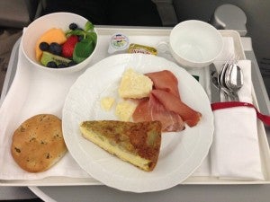 Rosemary bread, bowl of fresh fruit and a snack plate of Pdo ham, pecorino cheese, and artichoke pie.