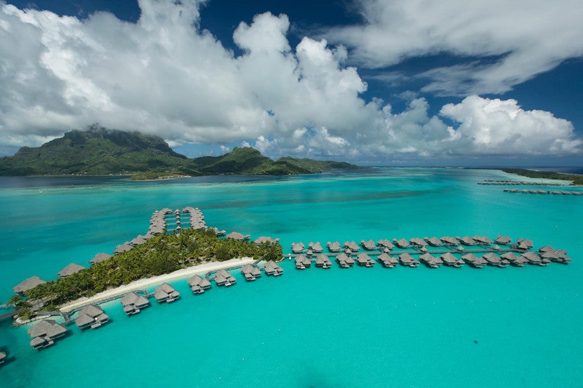 Stay in one of the overwater bungalows at The St. Regis Bora Bora Resort overlooking the lagoon.